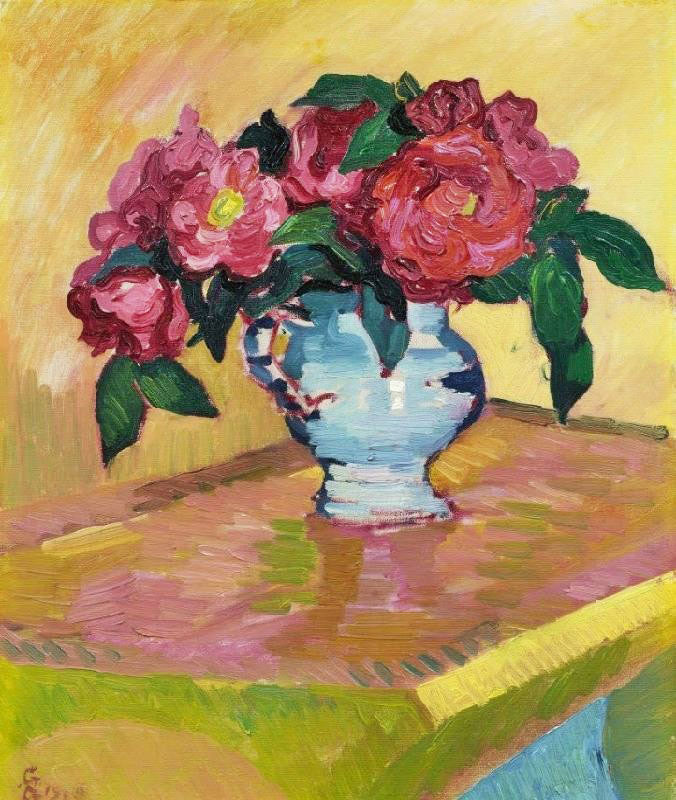 RED PEONIES IN PALE BLUE JUG ON A TABLE